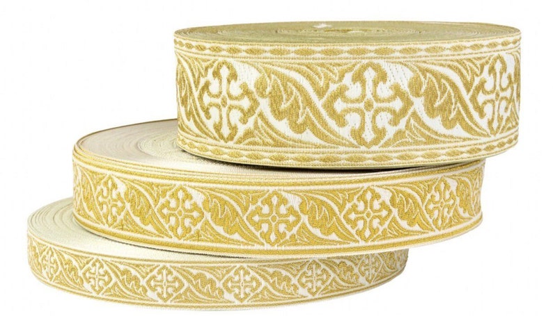 Op de afbeelding: Drie spoelen met witte bies met een gouden geborduurd patroon. Het patroon heeft een herhalend ontwerp van gestileerde bladeren en kruisen.