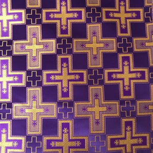 May include: Purple fabric with a repeating pattern of gold and purple crosses.