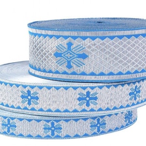 May include: Three rolls of blue and silver trim with a snowflake pattern. The trim is made of a woven fabric and has a slightly raised texture.