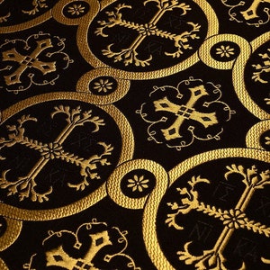May include: A black fabric with a gold pattern of repeating circles and crosses. The fabric has a textured, woven look.