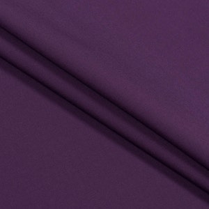 May include: A close-up of a smooth, deep purple fabric. The fabric is folded and has a subtle sheen.