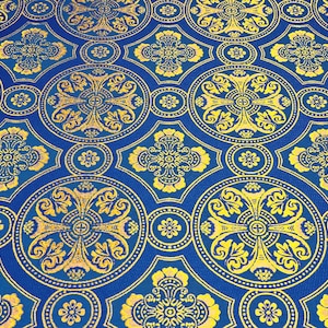 Puede incluir: Tela azul con un patr&oacute;n repetitivo de dise&ntilde;os florales y cruces dorados.