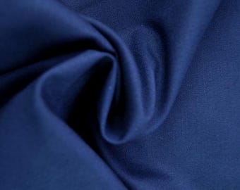 May include: Close-up of a deep navy blue fabric with soft folds and subtle texture. The material appears to be smooth and drapes elegantly, suggesting it could be used for clothing or home decor.
