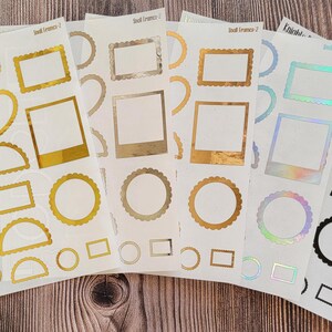 May include: Set of ten sheets of gold, silver, and iridescent sticker frames. Each sheet features a variety of shapes and sizes of frames, including circles, squares, rectangles, and hearts.