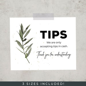 May include: A white sign with black text that reads "TIPS We are only accepting tips in cash. Thank you for understanding." The sign has a watercolor illustration of a green olive branch with gold glitter.