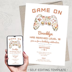 May include: A printable invitation for a birthday party with a video game theme. The invitation features a floral-patterned video game controller in shades of pink and green. The text "GAME ON" is in orange and the text "Brooklyn has reached level 10" is in brown. The invitation includes the date, time, and location of the party.