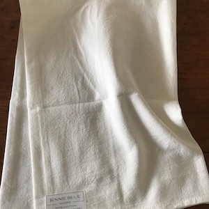 Pode incluir: Toalha de cozinha branca com um r&oacute;tulo que diz "Jennie Blue Maine 100% Algod&atilde;o Lavar na m&aacute;quina e secar www.jennieblue.com"