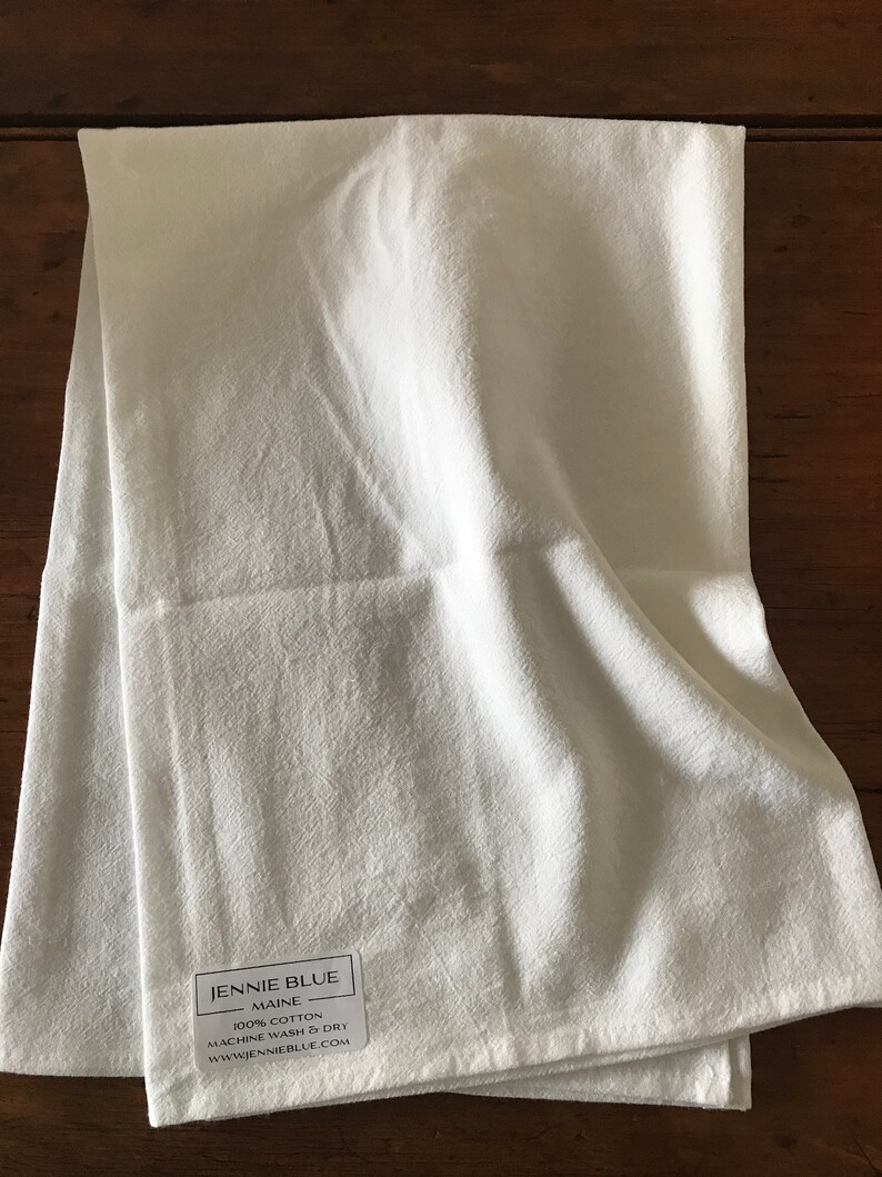 Peut inclure: Serviette de cuisine blanche avec une &eacute;tiquette indiquant "Jennie Blue Maine 100% Coton Lavage et s&eacute;chage en machine www.jennieblue.com"