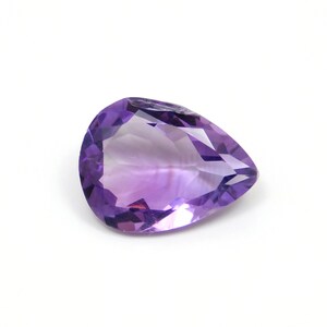 May include: A pear-shaped amethyst gemstone with a deep purple hue. The gemstone is faceted and has a high degree of clarity.