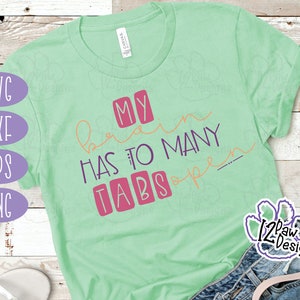 May include: A green t-shirt with the text "My brain has too many tabs open" in pink and purple lettering. The text is in a boxy font and the words "tabs" are in individual boxes.