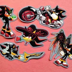 May include: Five different stickers featuring the character Shadow the Hedgehog from the Sonic the Hedgehog video game series. The stickers show Shadow in different poses, including riding a motorcycle, wearing a sombrero, and with angel wings.