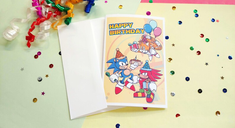 sonic birthday card with sonic, tails, and knuckles. Card says happy birthday on front. White envelope included
