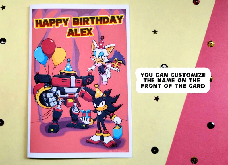 Personalized sonic birthday card laying on table that says Happy Birthday at the top in a colorful Sonic themed font. Image has Team Dark (Shadow, Rouge, and Omega) holding gifts.