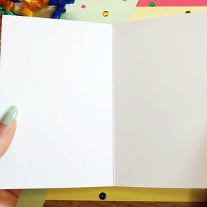 person holding open card. interior is blank.