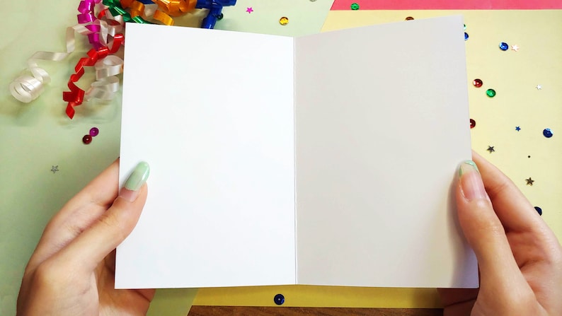 person holding open card. interior is blank.