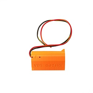Puede incluir: Componente impreso en 3D de color naranja con cables negros, rojos y amarillos conectados. El componente tiene el texto "RHIZ-PD USA" impreso en el lateral.