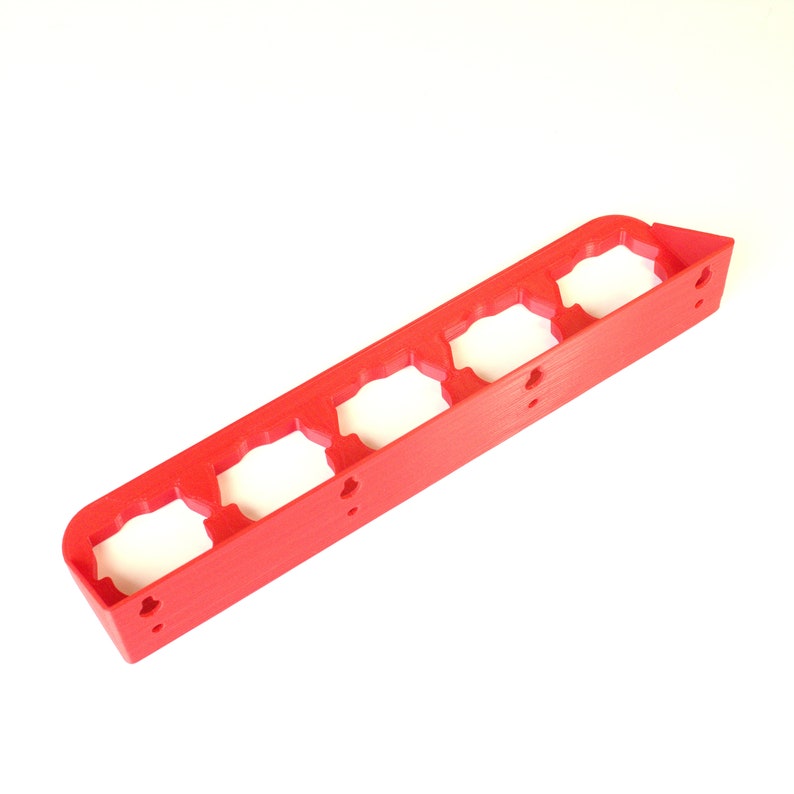 Puede incluir: Organizador de pl&aacute;stico rojo con cinco ranuras para guardar objetos peque&ntilde;os. El organizador tiene una forma rectangular y est&aacute; dise&ntilde;ado para montarse en la pared.