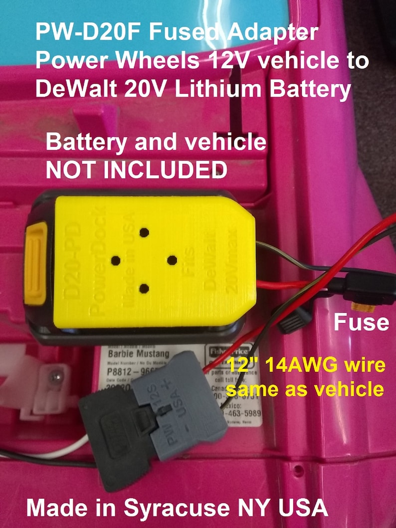 May include: A yellow and black adapter with the text "PW-D20F Fused Adapter" and "PowerDock Made in USA". The adapter is connected to a gray connector with the text "PW 125 USA+". The adapter is connected to a red and black wire. The text "12" 14AWG wire same as vehicle" is visible. The background is pink.