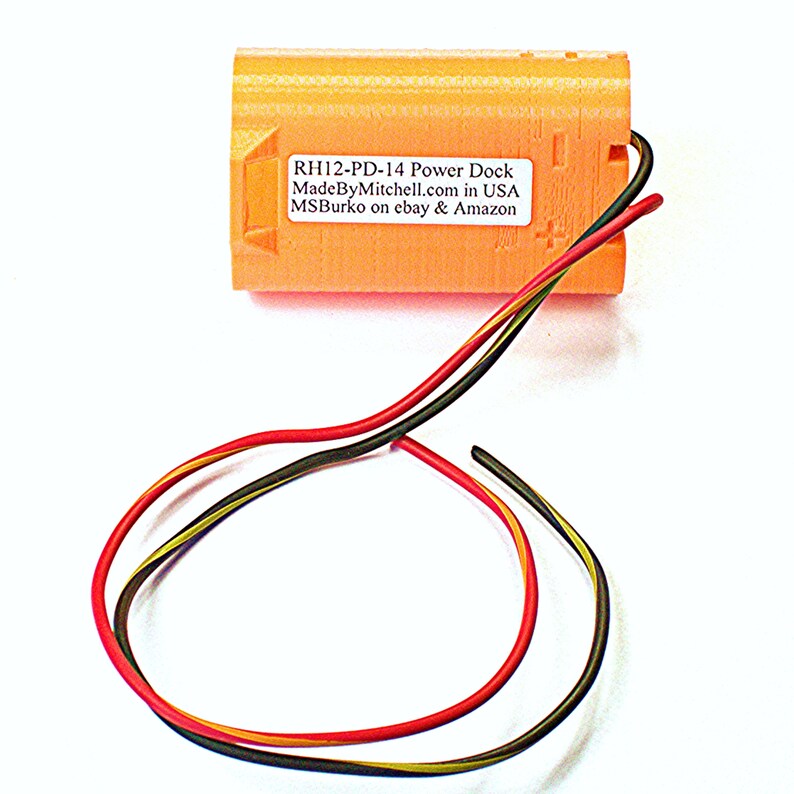 Puede incluir: Un muelle de alimentaci&oacute;n de pl&aacute;stico naranja con tres cables conectados. La etiqueta dice "RH12-PD-14 Power Dock MadeByMitchell.com in USA MSBurko en ebay & Amazon".