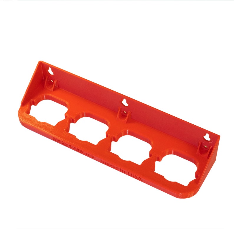 May include: Orange plastic wall mount with four circular cutouts for holding items. The wall mount has four holes for hanging and the text "M12x4-MRack made in USA" is printed on the bottom.