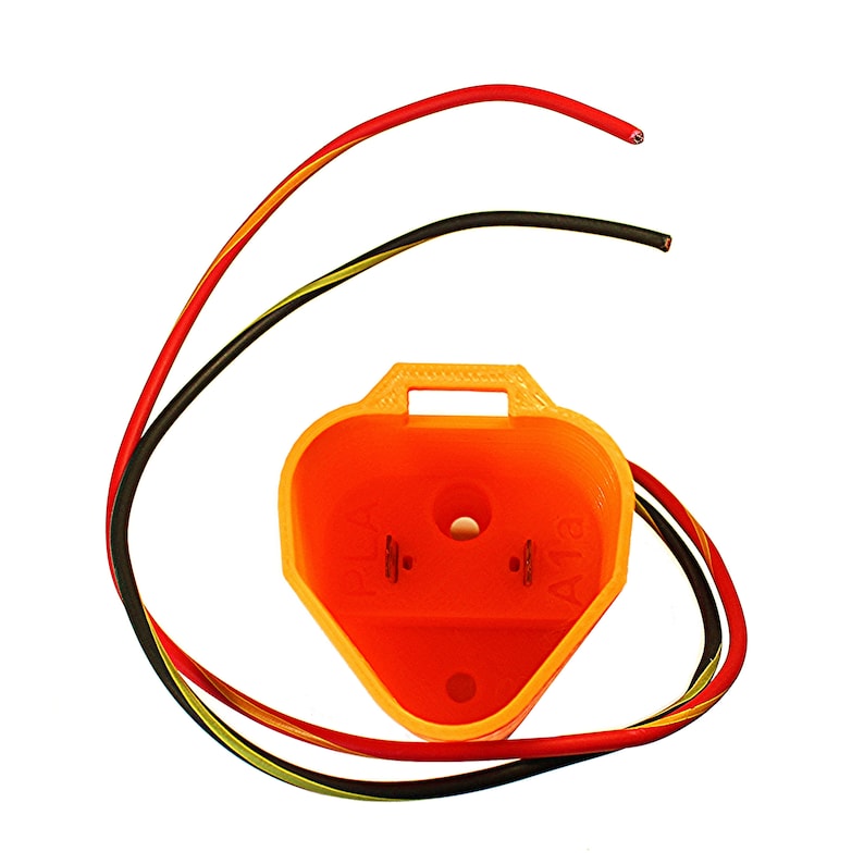 Puede incluir: Conector de pl&aacute;stico naranja con tres cables: rojo, negro y amarillo. El conector tiene dos clavijas met&aacute;licas y un peque&ntilde;o agujero en el centro.