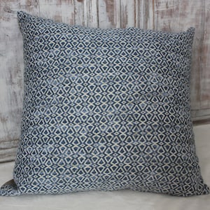 Peut inclure: Un coussin bleu et blanc à motif géométrique.