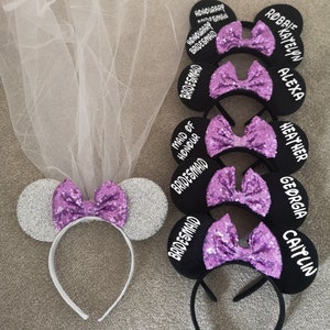 Puede incluir: Conjunto de seis orejas de ratón negras con diadema, lazos de lentejuelas moradas y texto blanco. El texto dice "Maid of Honour Bridesmaid", "Bridesmaid", "Bridesmaid", "Heather", "Alexa, Katelyn, Robbie" y "Georgia, Caitlin".