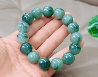 May include: A jade green beaded bracelet with round beads. The bracelet is made of natural jade stone and has a polished finish.