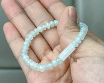 May include: A light green jade bracelet with round beads and a rectangular spacer bead.