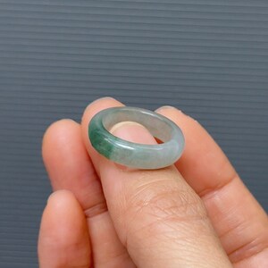 May include: A jade ring with a light green band and a darker green band.