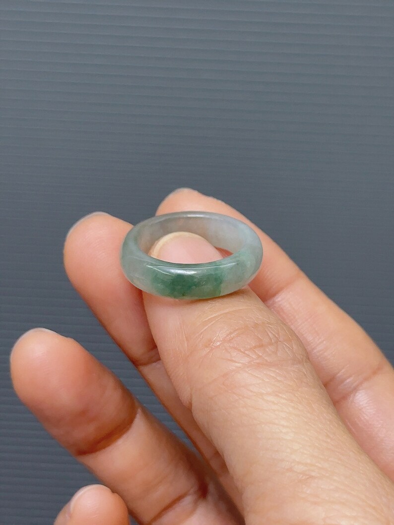 May include: A light green jade ring with a smooth, polished finish.