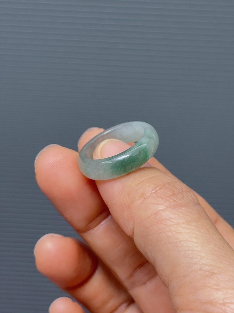 May include: A light green jade ring with a smooth, polished finish.