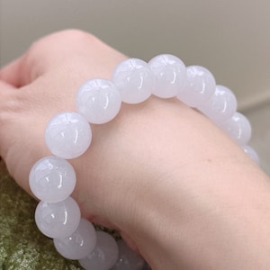 May include: A white jade bead bracelet with round beads.