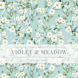 May include: A seamless pattern featuring white daisies with yellow centers on a light blue background. The daisies are arranged in a random pattern and are surrounded by green leaves. The text "VIOLET & MEADOW DESIGN SHOP" is displayed in a white banner at the bottom of the image.