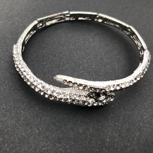 Pulsera vintage en tono plateado y cristal transparente con forma de serpiente.