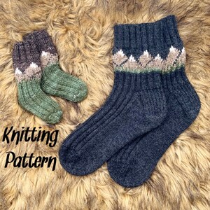 May include: Knitting pattern for a pair of socks. The socks are black with a green and white mountain design. The pattern is written on the image.