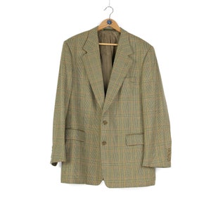 Könnte beinhalten: Ein brauner, beigefarbener und schwarzer karierter Blazer mit einem Knopfverschluss.