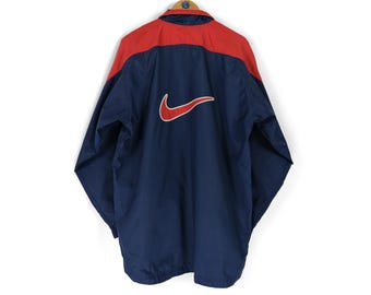 90-tals vintage NIKE vindjacka med swoosh-mönster baktill, marinblå och röd, storlek L XL, retro sportkläder