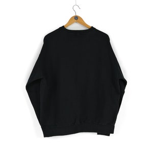 May include: A black sweatshirt with a crew neck and long sleeves.