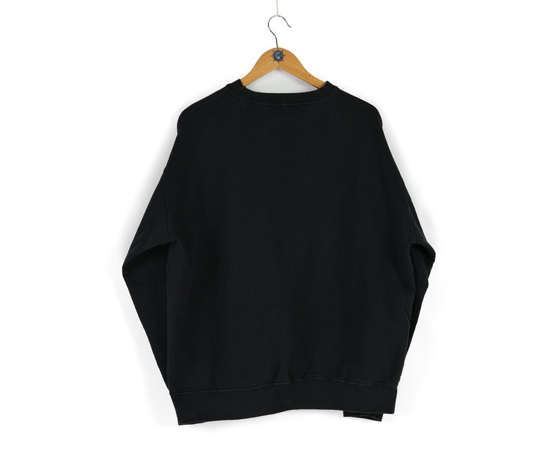 May include: A black sweatshirt with a crew neck and long sleeves.