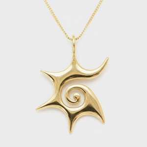 May include: A gold-toned pendant necklace featuring a stylized, asymmetrical star shape with a central spiral design. The pendant is suspended from a delicate, thin gold-toned chain, showcasing a smooth, polished metallic finish throughout the piece.