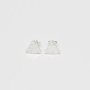 Op de afbeelding: Een paar zilveren driehoekige oorbel studs met een gehamerde textuur.