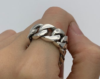 May include: A silver chain link ring with a chunky design.