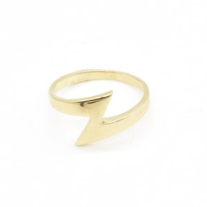 May include: A gold ring with a lightning bolt design.