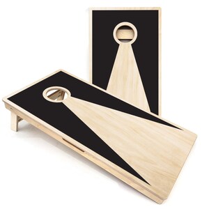 May include: Two wooden cornhole boards with black painted targets and a triangular shape. The boards are set up for a game of cornhole.