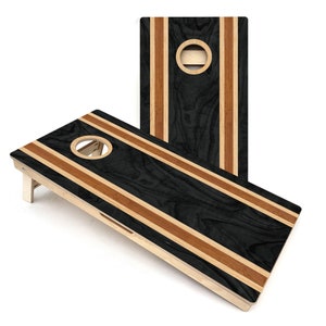 May include: A black and brown wooden cornhole game set with a striped design. The game board has a circular hole in the center.