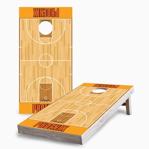 May include: A wooden basketball-themed cornhole game with a brown and orange design. The game features the word "PHOENIX" on the front of the boards.