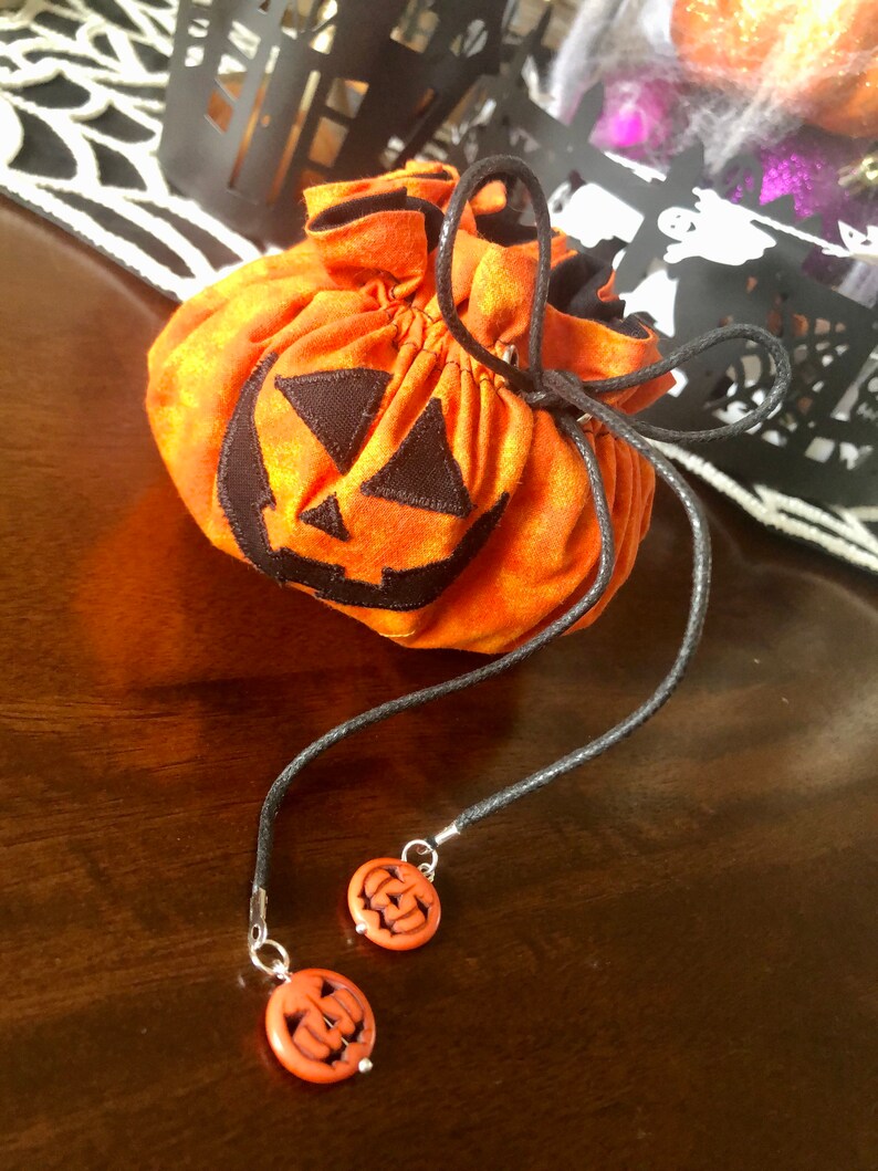 the bag closed in front of a decorative haloween background. the face of the jack-o-lantern is clearly visible