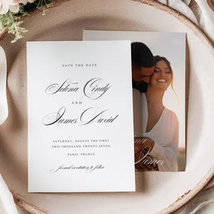 Puede incluir: Una invitación de boda con el texto "Save the Date" y los nombres Selena Cindy y James David. La invitación está sobre un plato de tonos neutros, con una foto de una pareja. Acentos florales y de tela completan la escena.