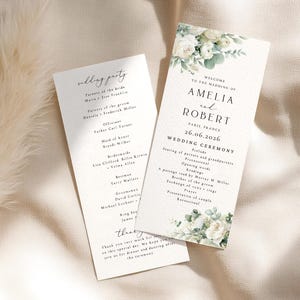 May include: Two white wedding ceremony programmes featuring black serif and script text. The top and bottom of the programmes are decorated with illustrations of white roses and green eucalyptus leaves. The text lists the wedding party and ceremony order.